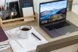 Werkplek van een kleine ondernemer met laptop en notitieboekje als beeld bij digitale werkstructuur