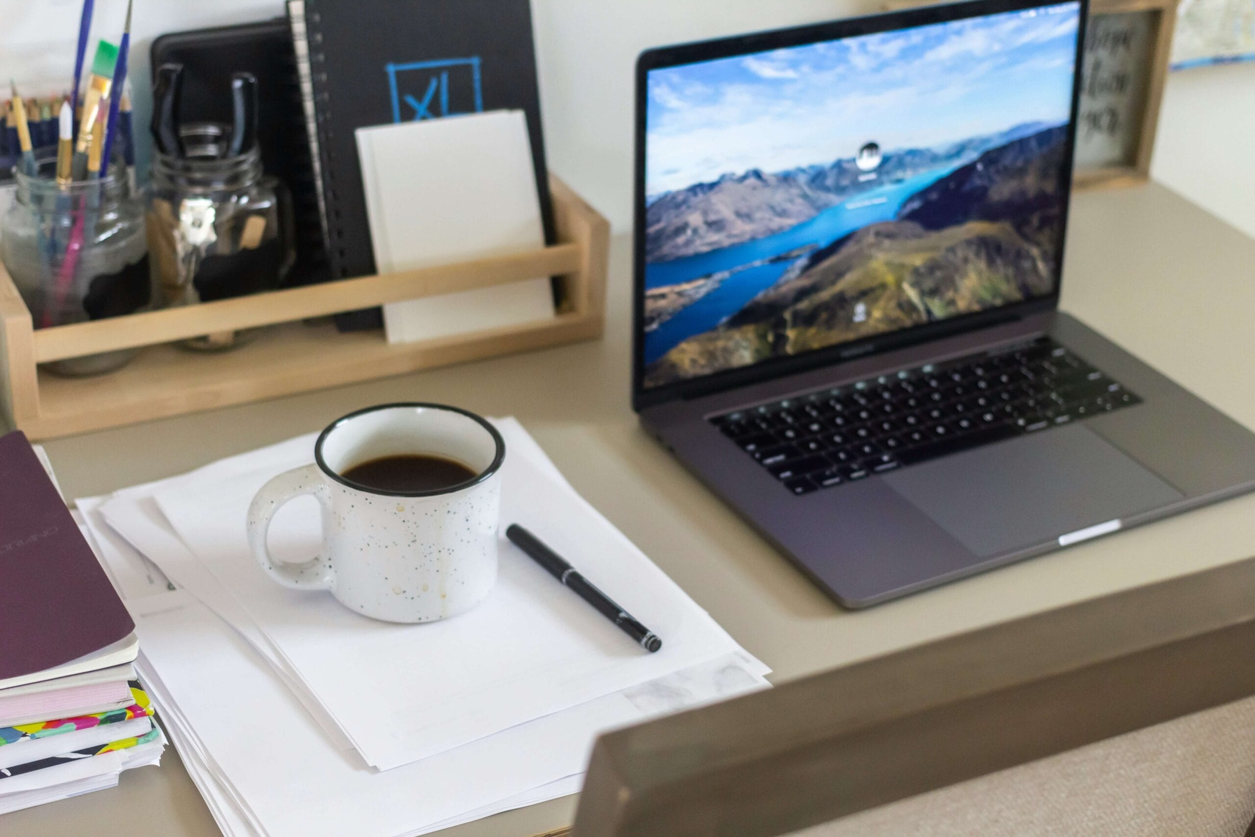Werkplek van een kleine ondernemer met laptop en notitieboekje als beeld bij digitale werkstructuur