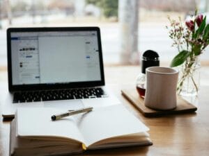 Bureau met laptop en notitieblok tijdens het afwegen van website laten maken of zelf bouwen